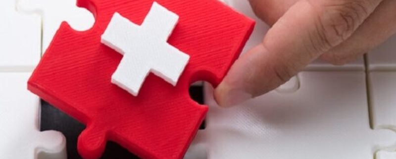 white medical cross on red puzzle piece_canstockphoto59692997-2-800x533