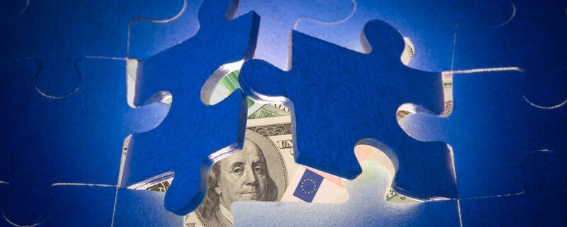 puzzle pieces with currency underneath_canstockphoto4886439 800x533