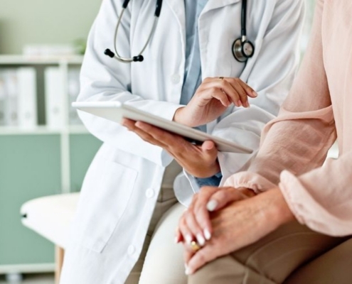 clinic, tablet and hands of doctor with patient_shutterstock_2472677019 800x533