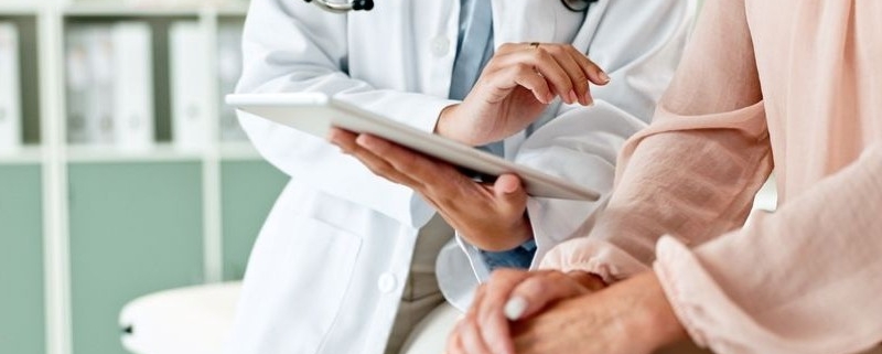 clinic, tablet and hands of doctor with patient_shutterstock_2472677019 800x533